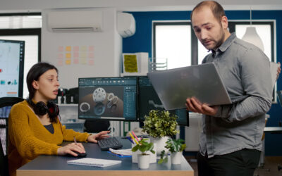 Project supervisor holding laptop and talking with engineer compering d industrial metallic pieces
