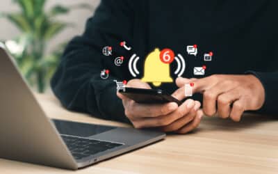 Man using his laptop then holds a smartphone after receiving many notifications