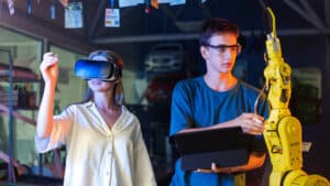 Teens doing experiments in robotics in a laboratory boy in protective glasses using tablet and girl