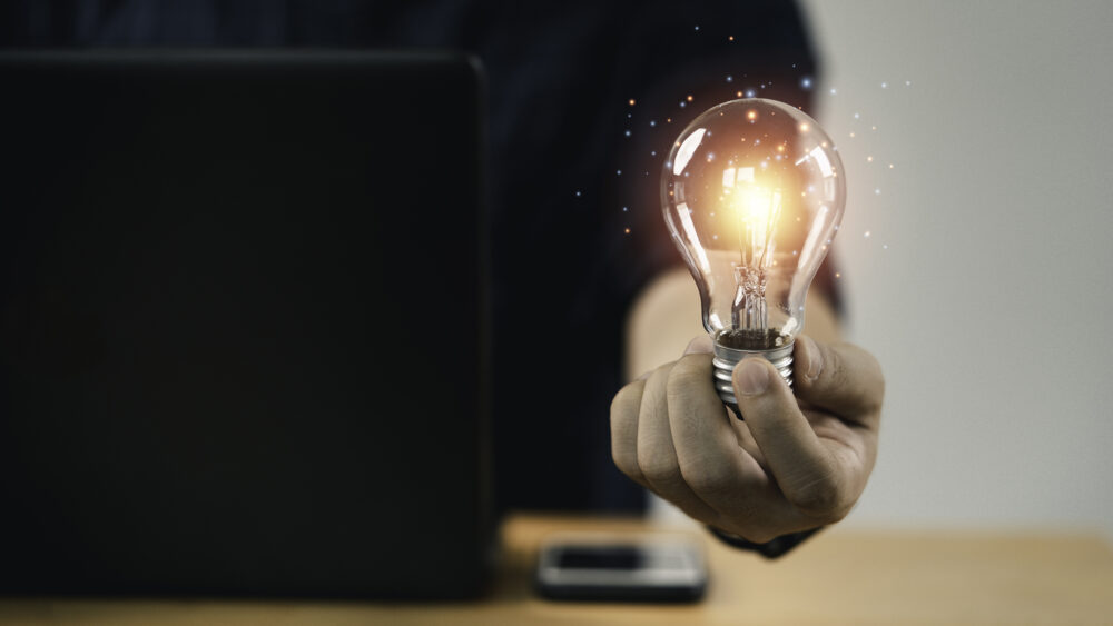 Businessman hand holding lightbulb with glowing light to creative smart thinking for inspiration and innovation with network concept
