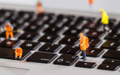Miniature workmen repairing a laptop keyboard
